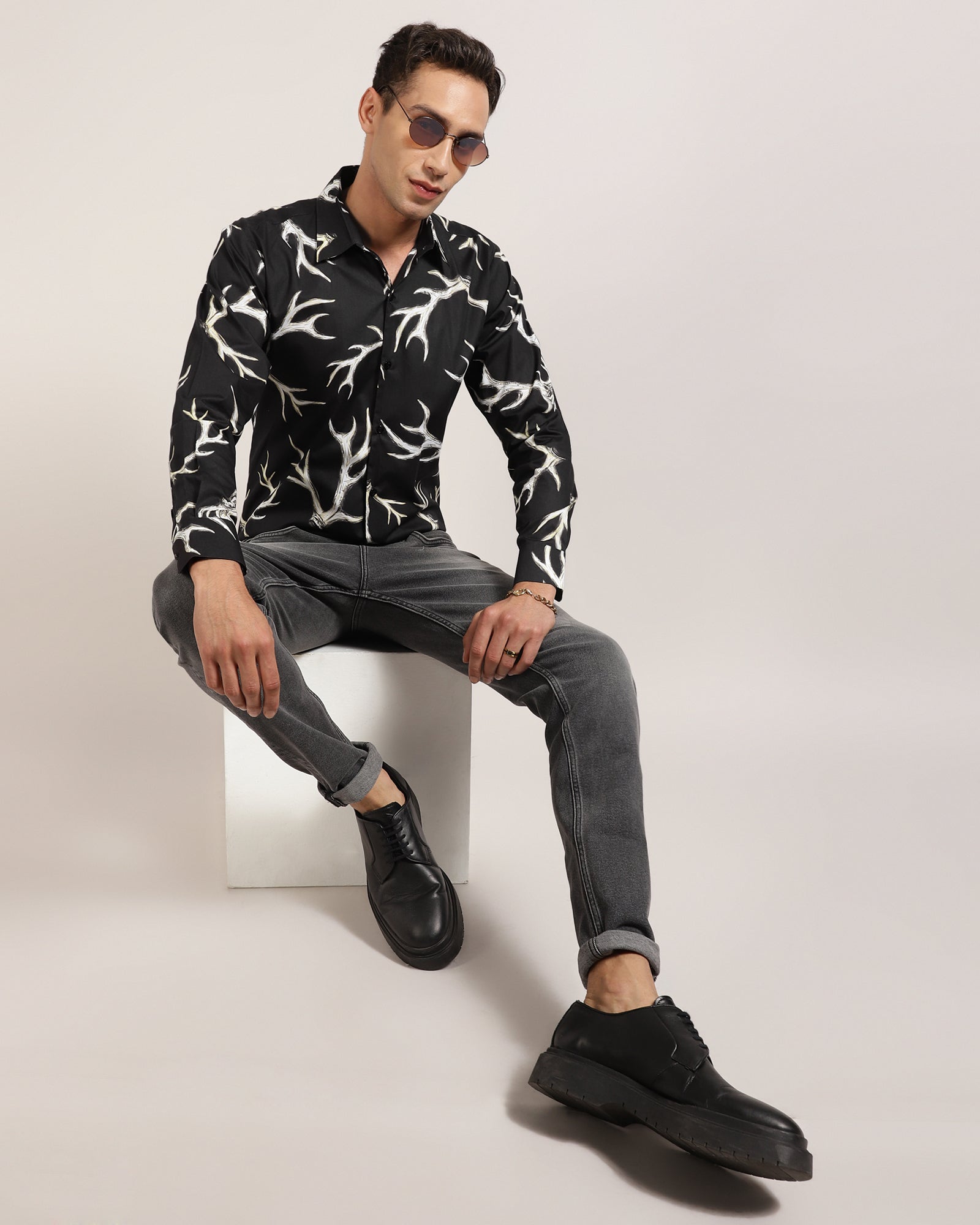 A man wearing a black abstract printed shirt by Monsui