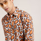 A fashion-forward men's shirt in a tiger print pattern, featuring a modern cut and high-end craftsmanship by Monsui