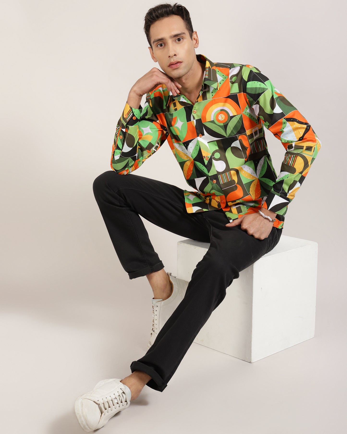 A man wearing a green abstract geometric print shirt.