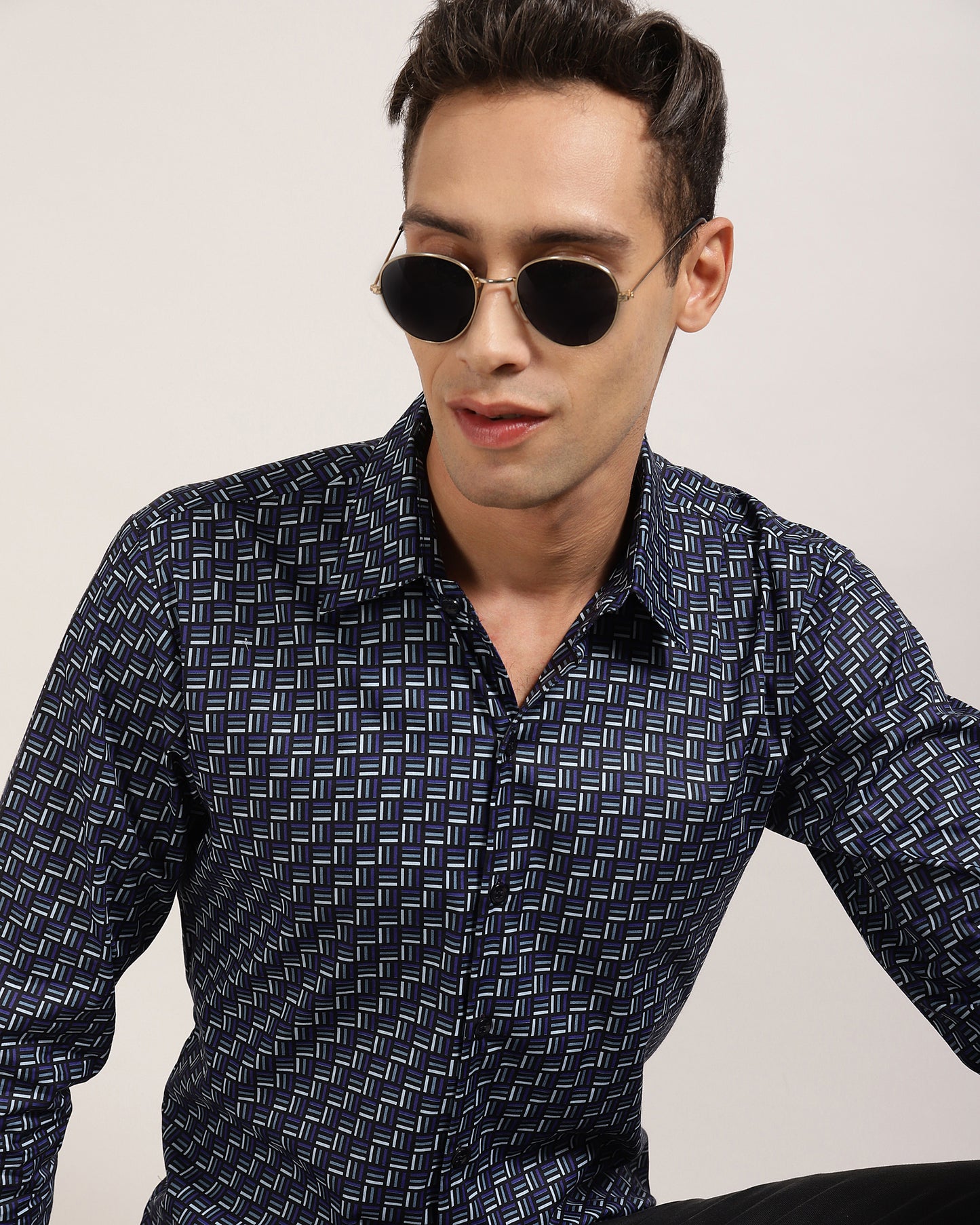 A model wearing a blue geometric print shirt